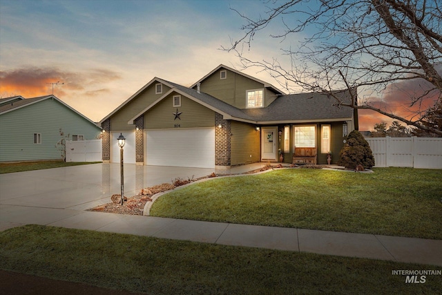 view of front of home with a garage and a lawn