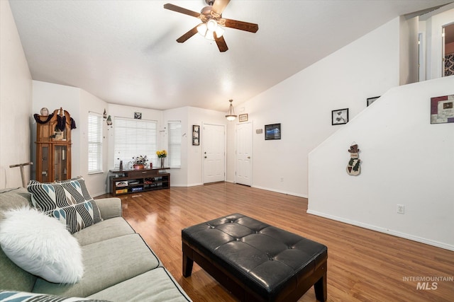 living room with lofted ceiling, hardwood / wood-style floors, and ceiling fan