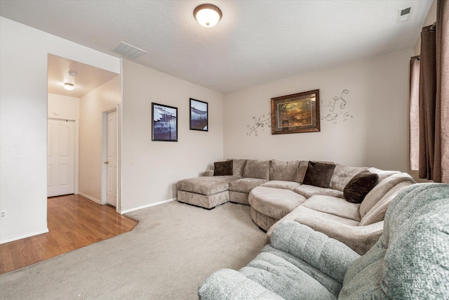 carpeted living room featuring a textured ceiling