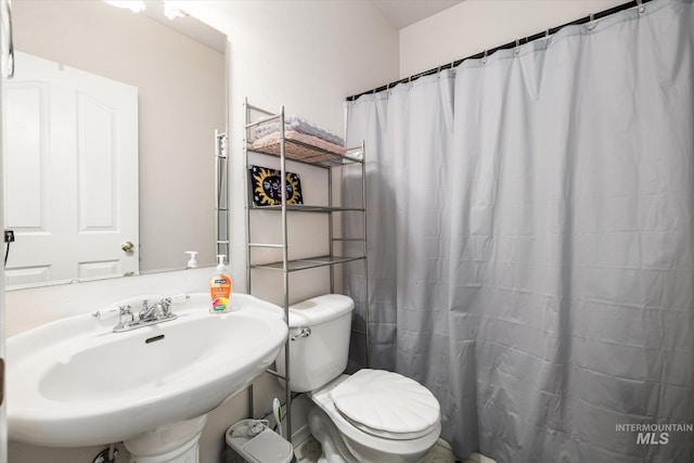 bathroom with a shower with curtain, toilet, and sink