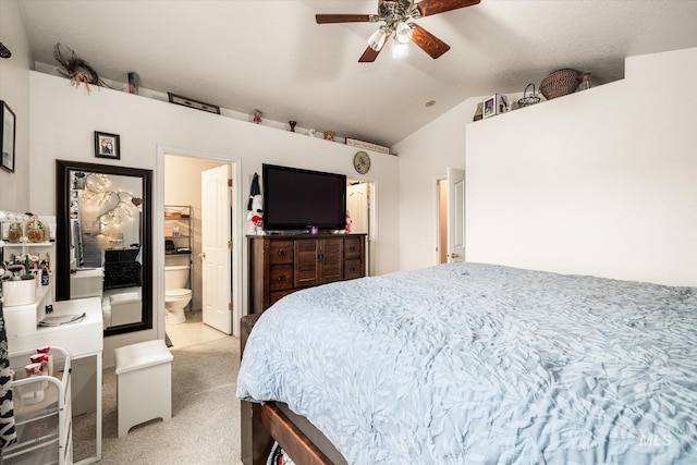 bedroom with light carpet, ensuite bath, vaulted ceiling, and ceiling fan