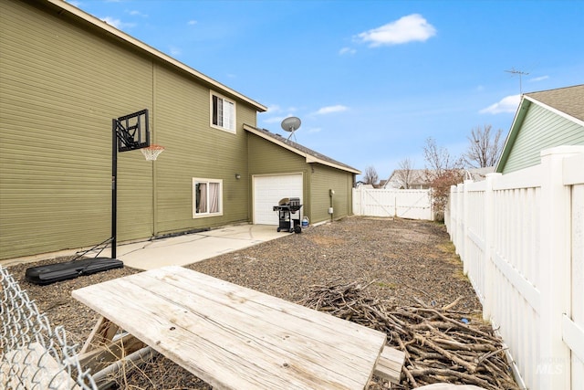 back of property with a garage and a patio