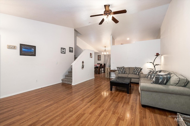 living room with hardwood / wood-style flooring, lofted ceiling, and ceiling fan with notable chandelier