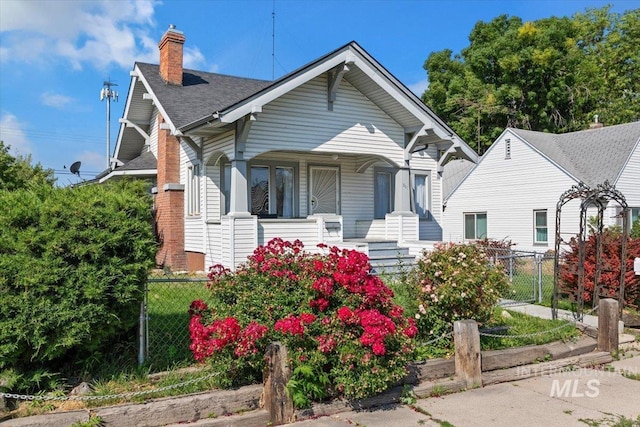 201 9th Ave N, Buhl, ID 83316 - bungalow-style home featuring covered porch, a chimney, fence, and roof with shingles