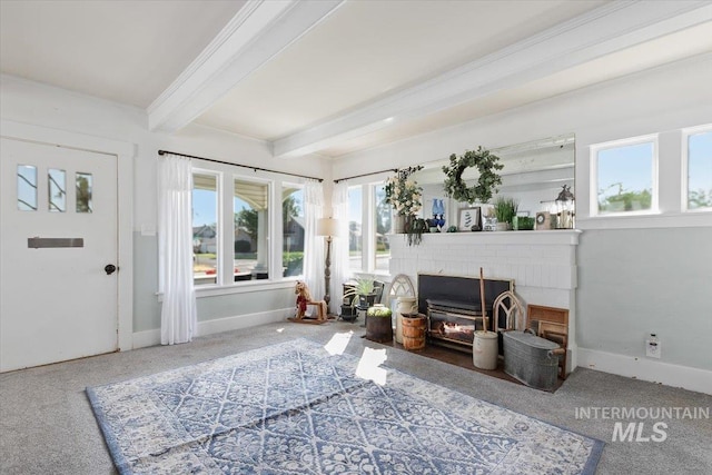 201 9th Ave N, Buhl, ID 83316 - living area featuring beam ceiling, plenty of natural light, baseboards, a brick fireplace, and carpet flooring