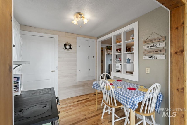 dining space featuring a textured ceiling and wood finished floors