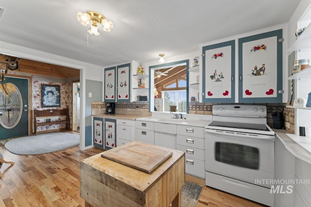 kitchen featuring open shelves, light countertops, decorative backsplash, light wood-type flooring, and white electric range