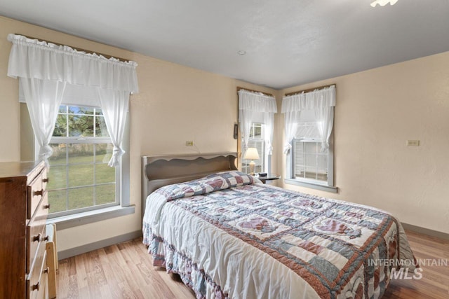 bedroom with baseboards and wood finished floors