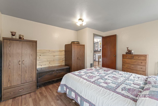 bedroom featuring wood finished floors and visible vents