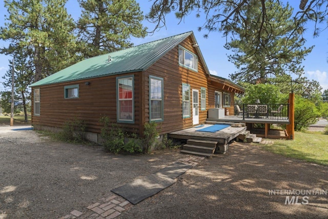 exterior space with a wooden deck and metal roof