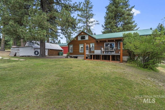 rear view of house with a lawn, a wooden deck, and metal roof