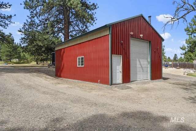 detached garage featuring dirt driveway