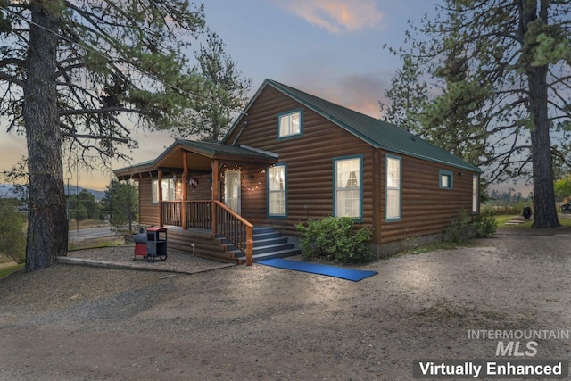 chalet / cabin featuring log veneer siding and metal roof