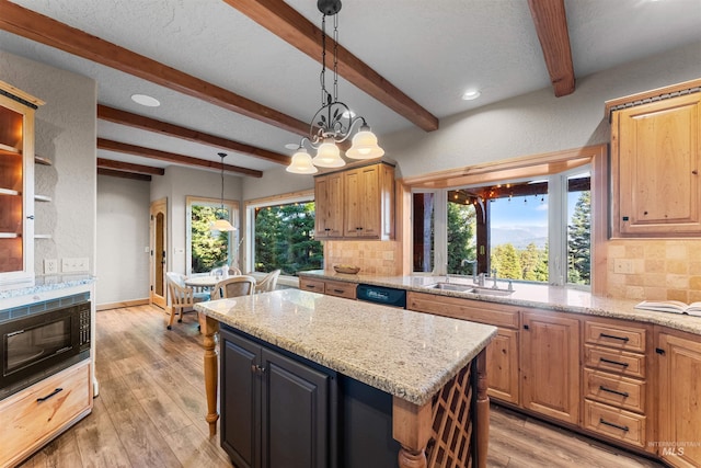 kitchen with a center island, tasteful backsplash, sink, light wood-type flooring, and light stone counters