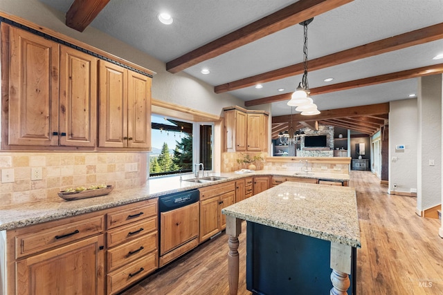 kitchen featuring pendant lighting, dishwashing machine, decorative backsplash, sink, and light wood-type flooring