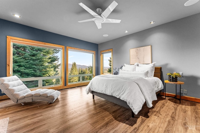 bedroom featuring a skylight, light hardwood / wood-style flooring, and ceiling fan