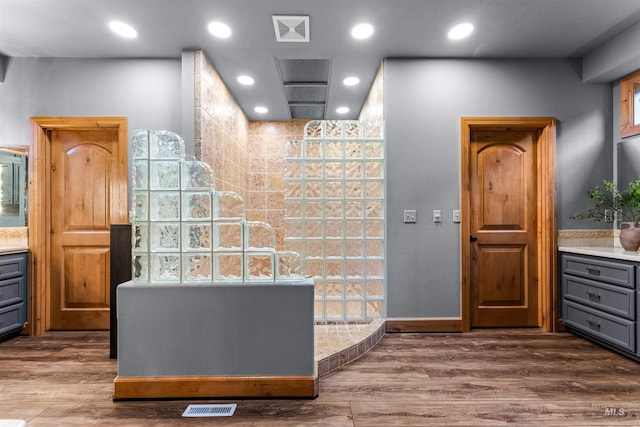 bathroom with vanity, hardwood / wood-style flooring, and walk in shower