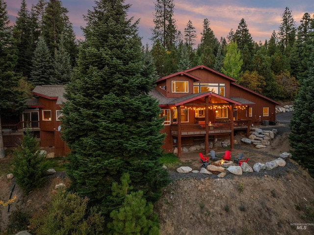 back house at dusk with a wooden deck