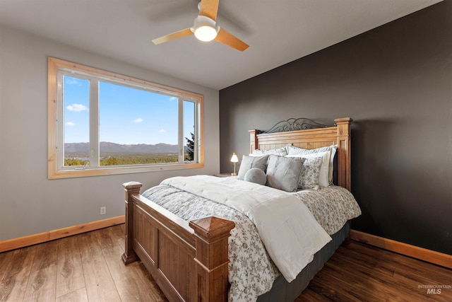 bedroom featuring a mountain view, dark hardwood / wood-style floors, and ceiling fan