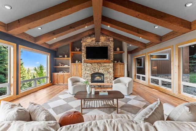 living room with plenty of natural light, light wood-type flooring, built in features, and vaulted ceiling with beams