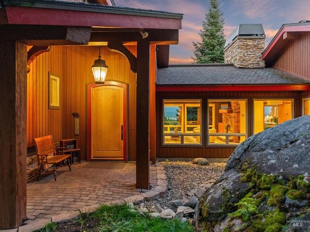 back house at dusk featuring a patio