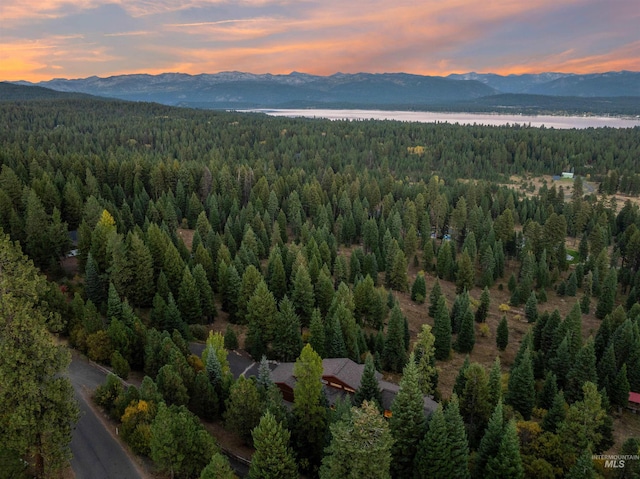 aerial view at dusk featuring a water and mountain view