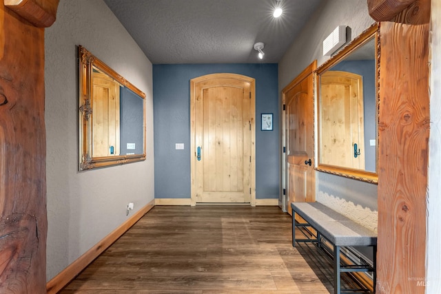 interior space featuring a textured ceiling and wood-type flooring