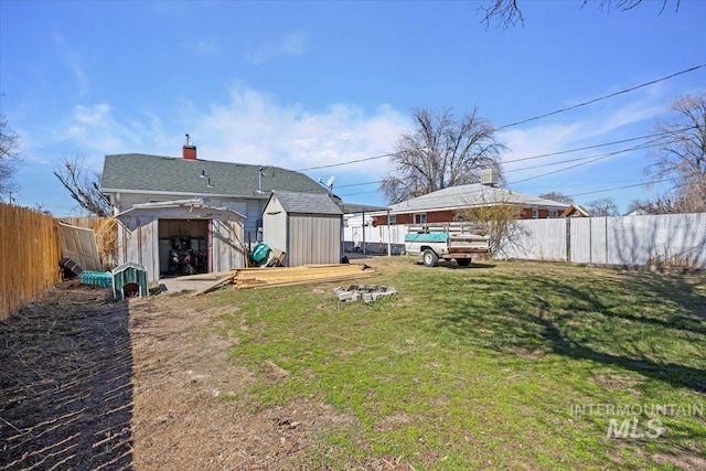view of yard with an outdoor structure, a fenced backyard, and a shed