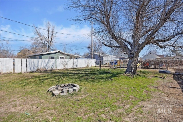 view of yard with an outdoor fire pit and fence