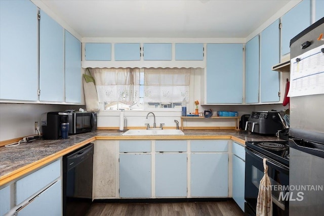 kitchen with a sink, dark wood-style floors, black appliances, and blue cabinetry