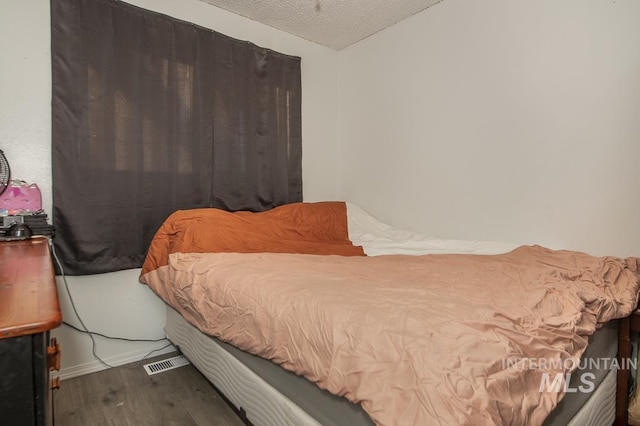 bedroom with hardwood / wood-style flooring and a textured ceiling