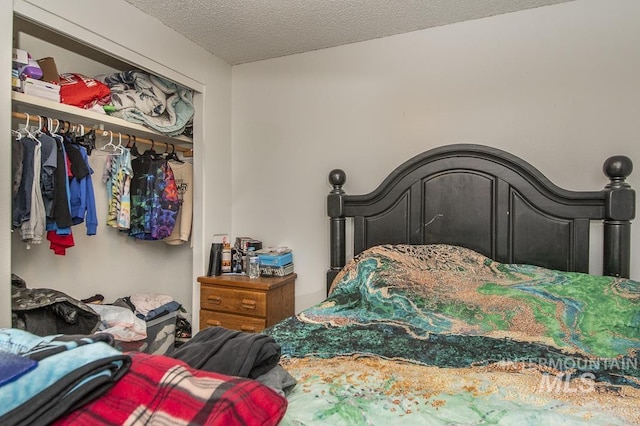 bedroom with a textured ceiling and a closet