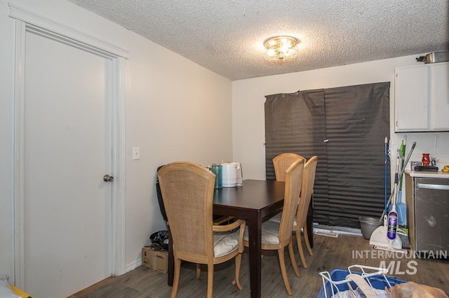 dining space featuring a textured ceiling, dark hardwood / wood-style floors, and wine cooler