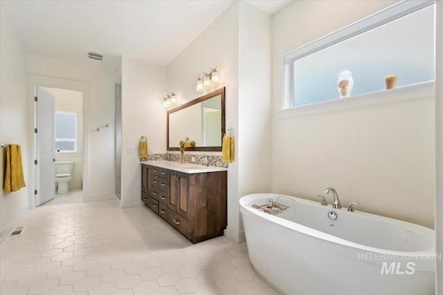 7478 W Palamas, Eagle, ID 83616 - bathroom featuring a freestanding tub, vanity, toilet, and tile patterned flooring