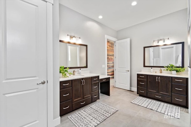 bathroom featuring two vanities, a sink, and recessed lighting