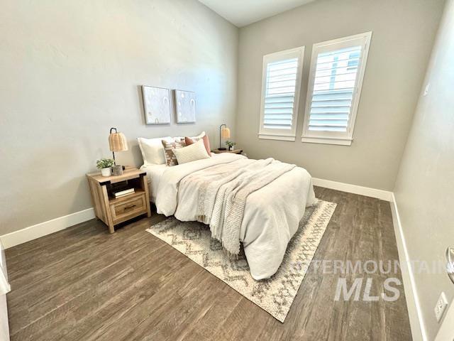 bedroom featuring baseboards and dark wood-type flooring