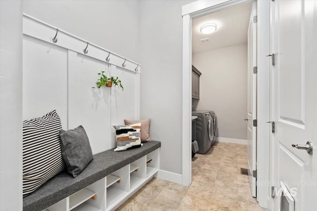 mudroom with separate washer and dryer, visible vents, and baseboards