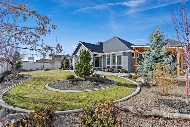 rear view of house featuring fence and a yard