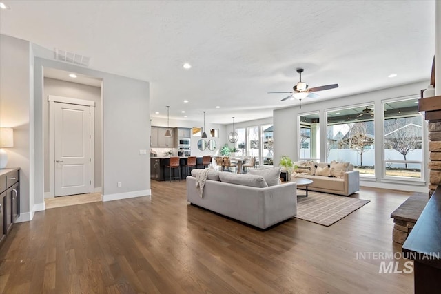 living area featuring baseboards, visible vents, a ceiling fan, wood finished floors, and recessed lighting