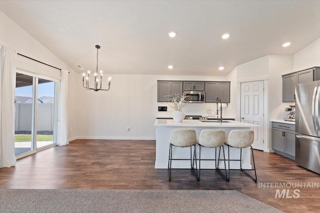 19558 Delmarva Ave, Caldwell, ID 83605 - kitchen featuring gray cabinetry, appliances with stainless steel finishes, a chandelier, an island with sink, and lofted ceiling