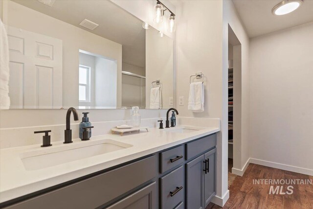 19558 Delmarva Ave, Caldwell, ID 83605 - full bathroom with double vanity, wood finished floors, a spacious closet, and a shower stall