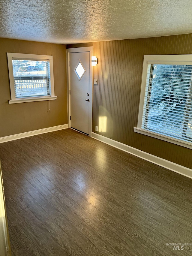 foyer with dark hardwood / wood-style floors and a textured ceiling