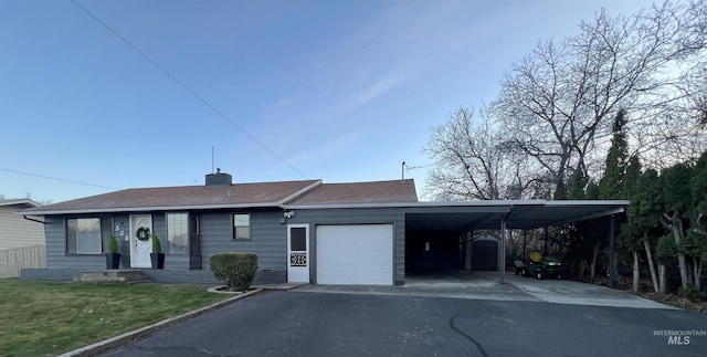 view of front of house with a garage, a carport, and a front lawn