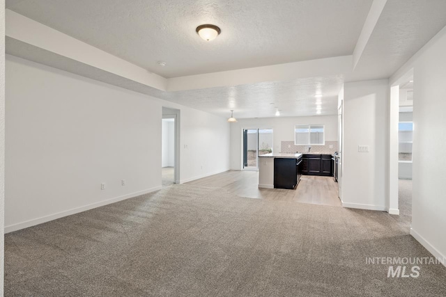 17892 Sunset Ridge Ave, Nampa, ID 83687 - unfurnished living room with a textured ceiling, baseboards, and light carpet