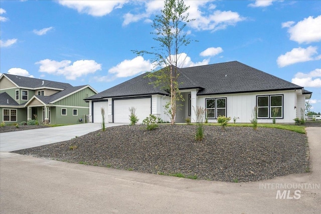 view of front of house featuring a garage, concrete driveway, and a shingled roof