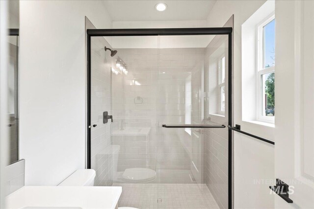 full bathroom with a stall shower and toilet