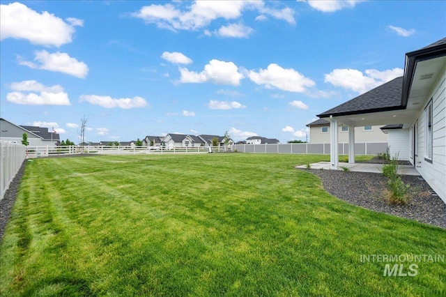 view of yard featuring a fenced backyard and a residential view