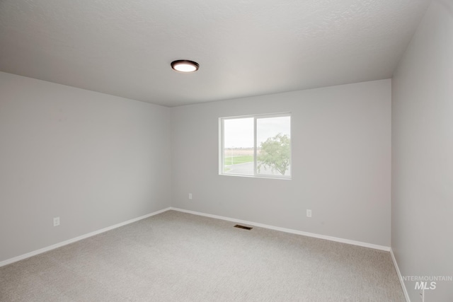 empty room with a textured ceiling and carpet