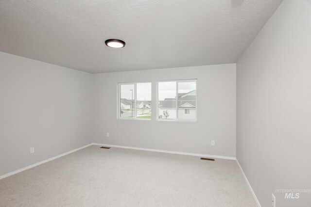 empty room with a textured ceiling and carpet