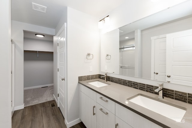 bathroom with tasteful backsplash, vanity, and hardwood / wood-style floors